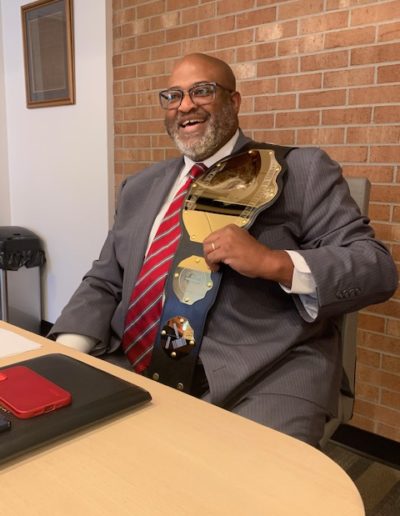 Paul Meggett with "The Office of General Counsel Title Belt"